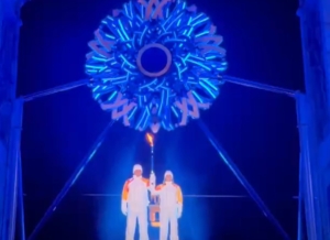 Torchbearers Alberto Tomba and Deborah Compagnoni stand beneath the Olympic cauldron, which is still unlit