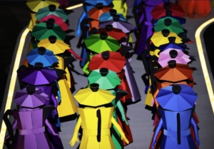 Performers disguised as human-sized Bialetti coffee makers